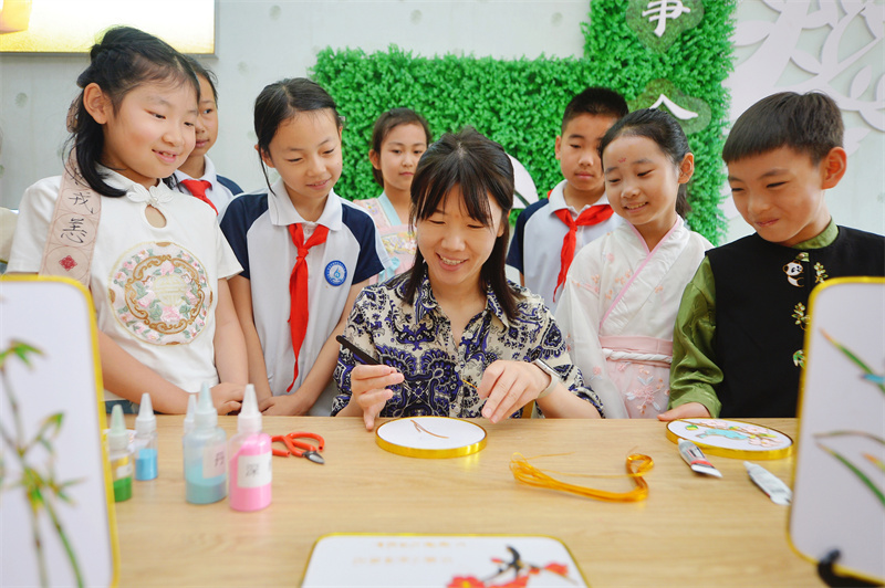 2026年6月17日，在山东省青岛市城阳区白云山学校开展的“传统文化润童心”主题活动上，老师在指导学生学习掐丝珐琅。王海滨摄