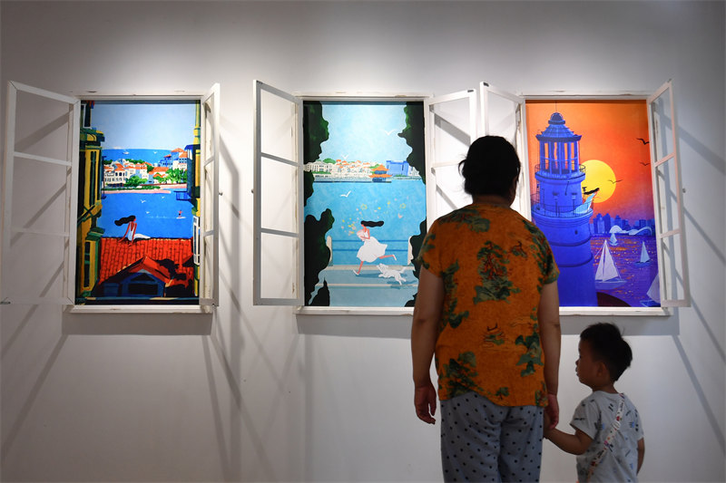 2026年6月26日，在山东省青岛市市北区无棣路“波螺油子·拾贰阶”历史街区，游客在“螺”美术馆参观综合插画展。王海滨摄