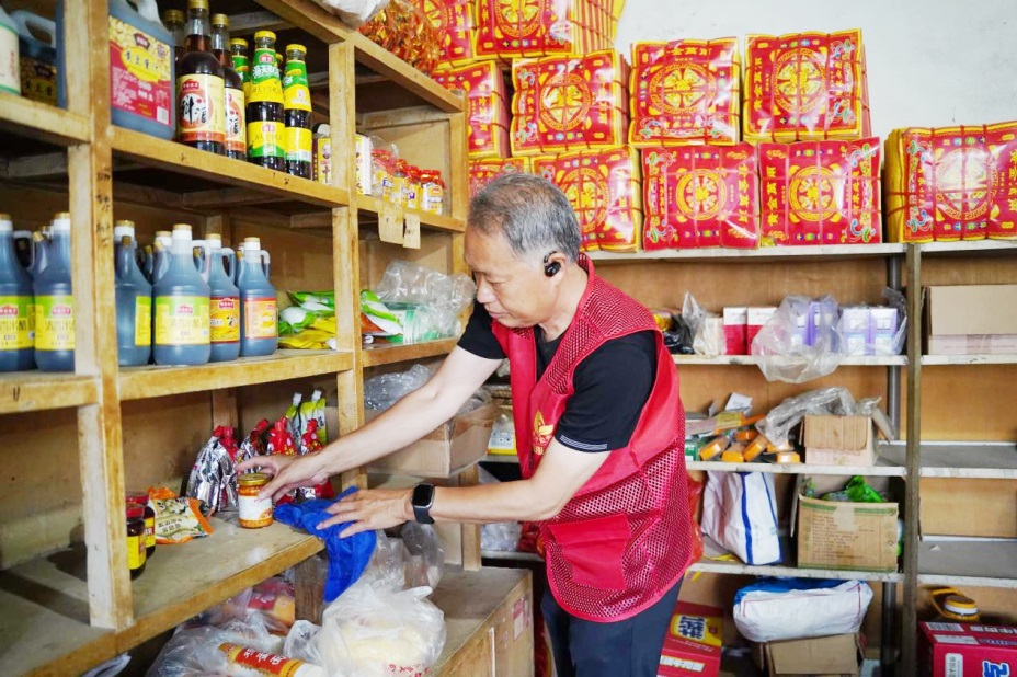 “清風煙草”志願者為老年零售戶整理貨架