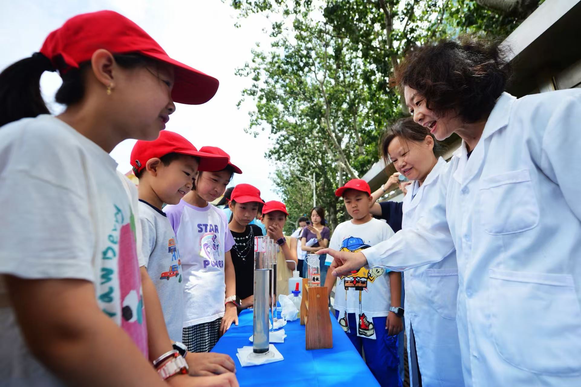 8月12日，在山東省青島市海泊河污水處理廠，工作人員為學生演示科學小試驗——污水淨化。