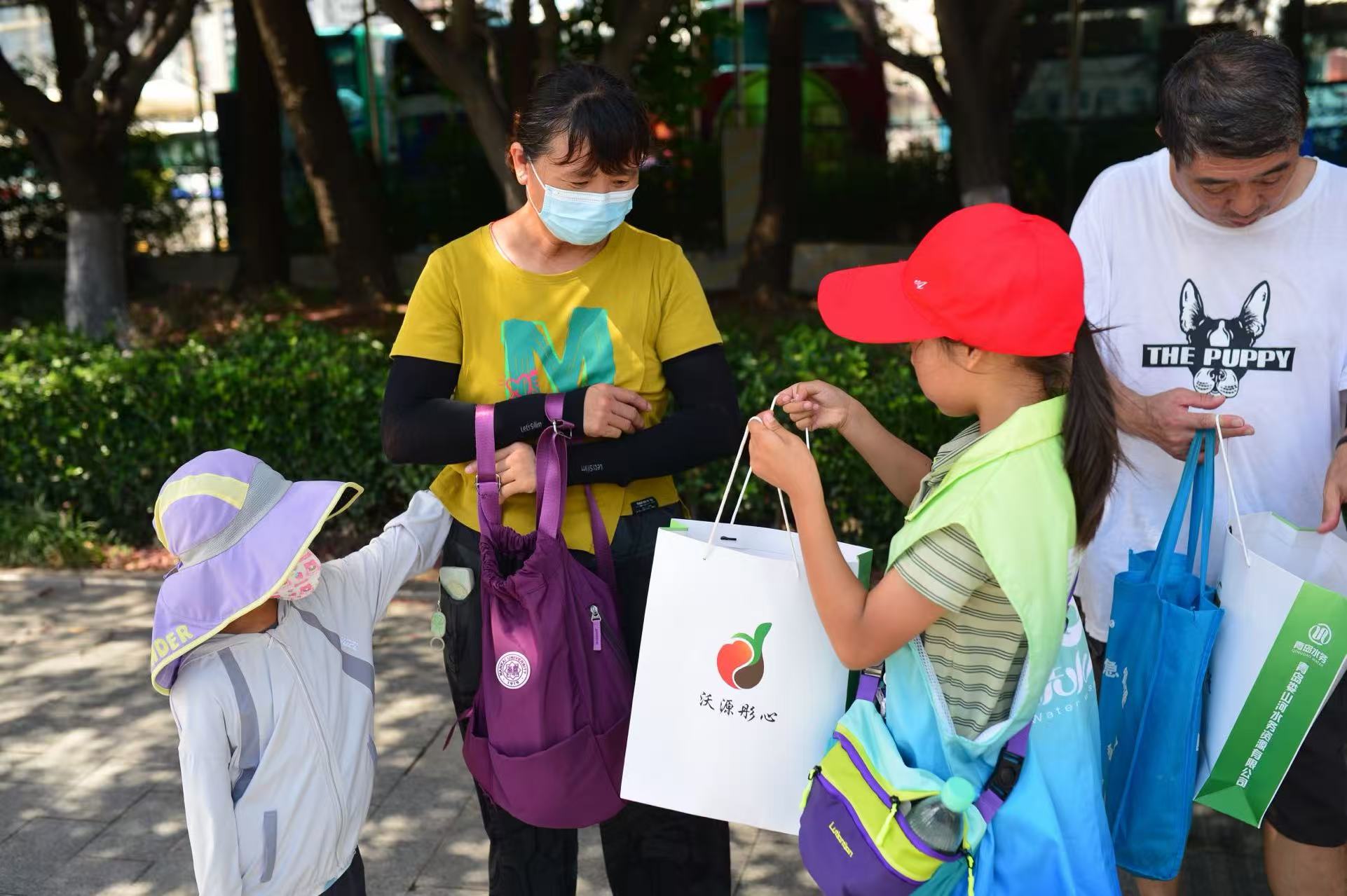8月12日，在山東省青島市海泊河再生水廠附近，學生們向過往市民宣傳節水知識、贈送有機營養土。