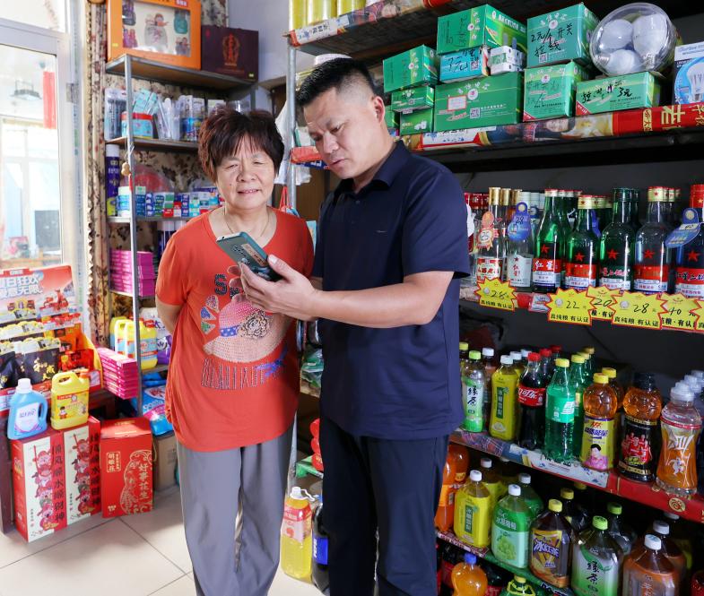 客戶經理徐寶平向惠惠超市店主劉俊香面對面解答數字化店鋪管理工具操作問題