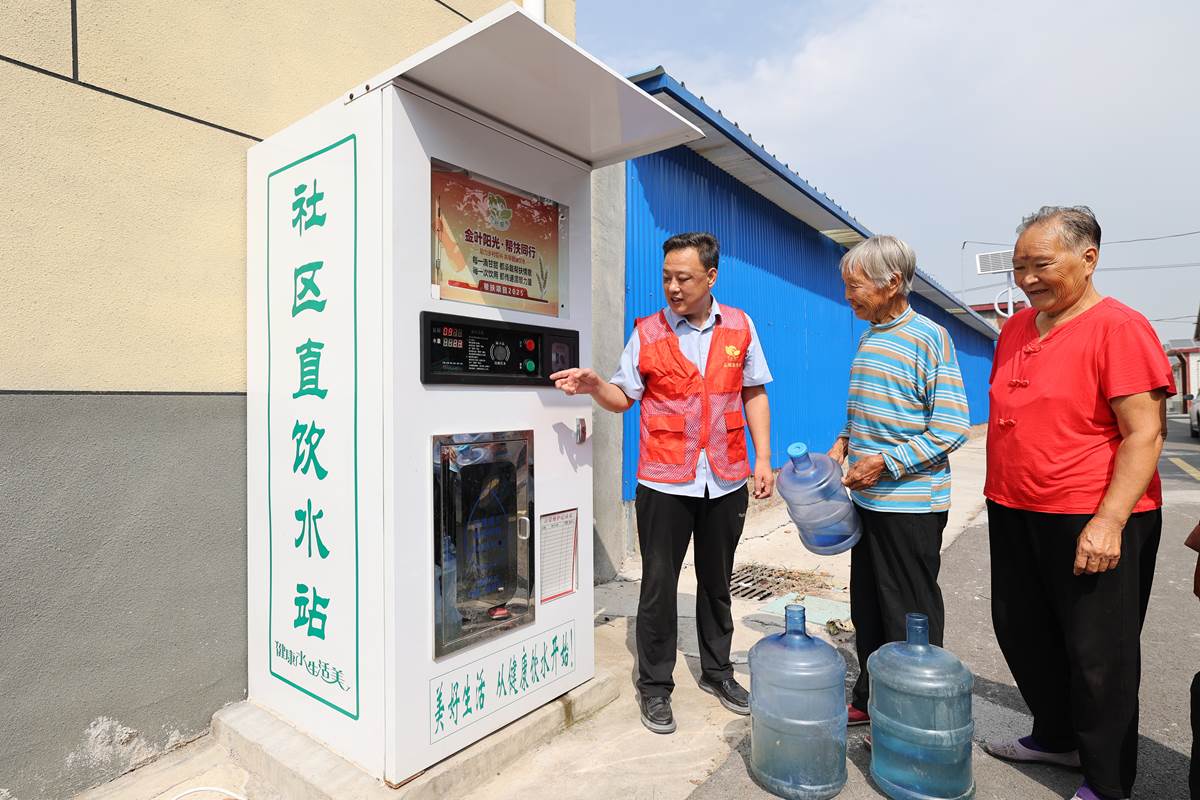 聯村干部王韶峰為村民講解淨水機使用方法