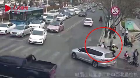 青岛：男孩飞奔横穿马路被执勤交警一把拽回
