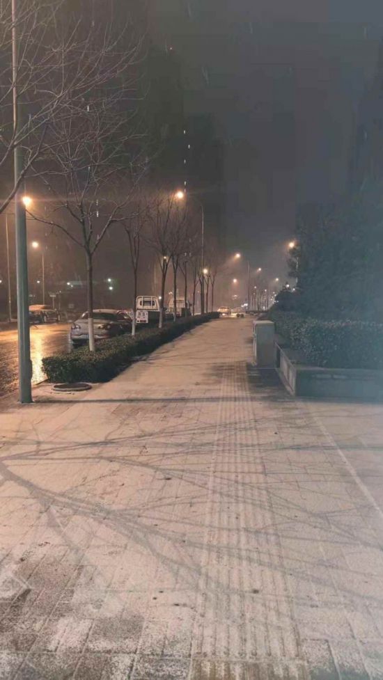 28日晚10點左右，濟南市高新區舜義路人行道有了一層薄薄的白雪。