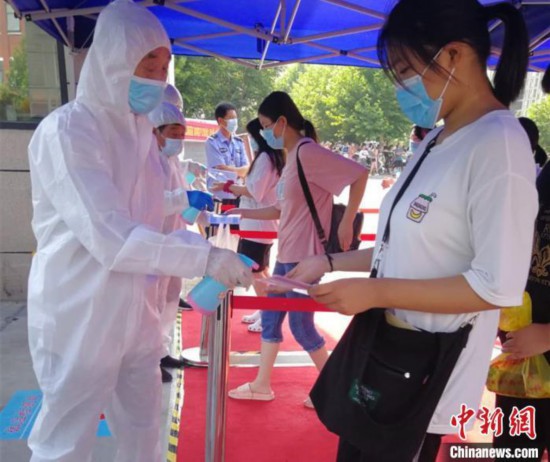 資料圖：2020年7月7日，河南鄭州，醫務人員為進入考點的考生進行體溫檢查和消毒。河南省衛健委供圖